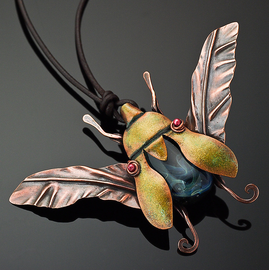 ​​Kharisma Sommers, Quincy, IL, U.S., “Jewel Beetle” (8.9 cm wide) ​(3.5 in wide) Copper, glass bead, leather, guilder’s paste -- www.foldforming.org
